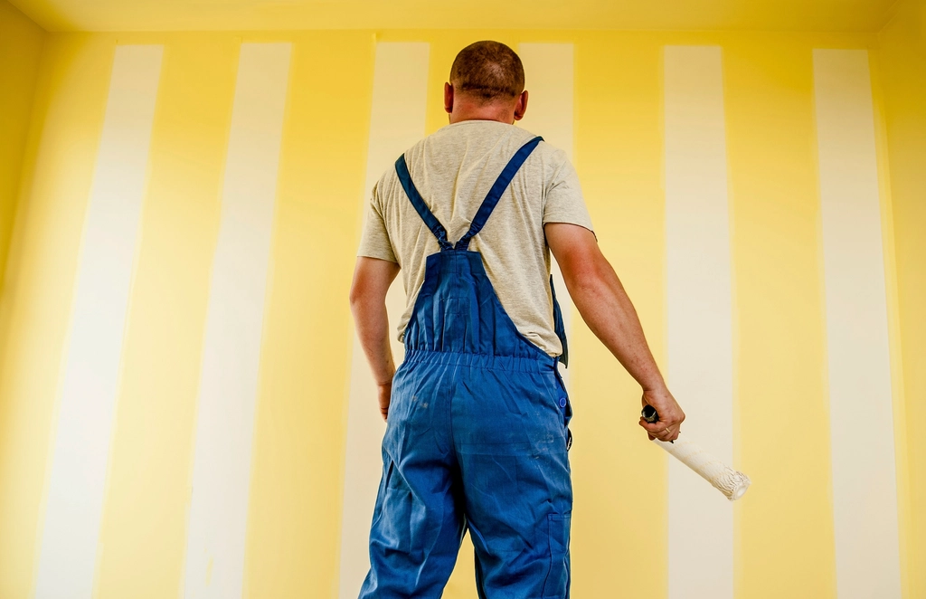OLNA decorator rolling paint onto a freshly prepared wall